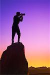 Homme sur la falaise avec des jumelles