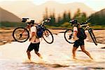 Couple Crossing River with Mountain Bikes