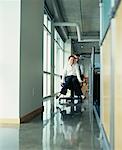 Man Pushing Woman on Chair in Office