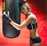 Femme se penchant sur le sac de boxe