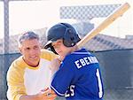 Man Coaching Boy with Batting