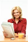 Woman Eating Breakfast and Reading Newspaper