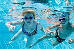 Couple nage sous l'eau dans la piscine