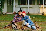 Couple assis sur le tas de feuilles