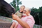 Mann Fütterung Pferd mit Enkel