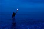 Woman Standing in Water Holding Flare