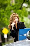 Businesswoman Using Laptop and Cellular Phone Outdoors