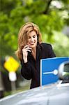 Femme d'affaires avec ordinateur portable et téléphone cellulaire à l'extérieur