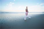 Femme faisant du Yoga sur la plage