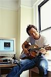 Man Playing Guitar in Home Office