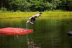 Homme sautant dans le lac