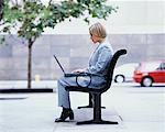 Woman Using Laptop on Park Bench