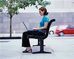Woman Using Laptop on Park Bench