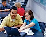 Mann und Frau mit Notebook im Café