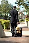 Homme d'affaires avec ours en peluche dans les bagages