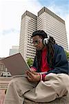 Man Listening to Headphones and using Laptop Computer