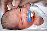 Hands Examining Ear of Newborn