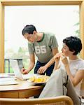 Couple Paying Bills and Eating Oranges