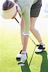 Woman Taking Golf Ball Out of Cup