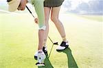 Woman Taking Golf Ball Out of Cup