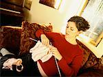 Femme enceinte tricot sur canapé