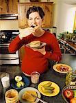 Pregnant Woman Eating in Kitchen