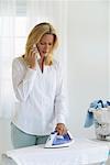 Woman Doing Laundry and Using Phone