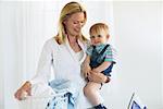 Mother Holding Son while Ironing