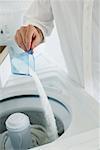 Man Pouring Detergent into Washing Machine