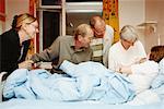 Family Visiting New Mother and Baby in Hospital