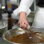 Baker, casser un œuf dans la pâte à gâteau au chocolat