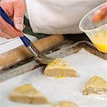 Baker Putting Egg Glaze on Dough