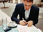 Businessman at Cafe Writing Postcard