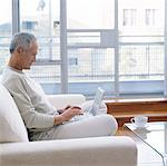 Mann mit Laptop auf Sofa