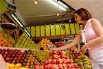 Femme devant un Stand de fruits