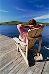 Man Relaxing in Adirondack Chair On Dock