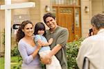 Realtor Taking Picture of Family And Newly Purchased Home