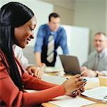 Businesswoman Using Electronic Organizer in Meeting