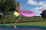 Boy Playing Frisbee on Trampoline