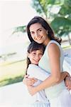 Portrait of Mother and Daughter Hugging Outdoors