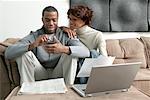 Couple Using Laptop Computer And Electronic Organizer