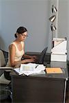 Femme en tapant sur l'ordinateur portable au bureau