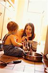 Mère de jouer avec le bébé sur le plancher de la cuisine