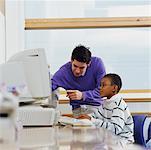 Enseignant aidant élèves sur ordinateur