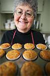 Femme avec des Muffins au four fraîches