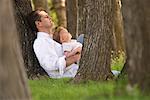 Père et enfant assis sous un arbre