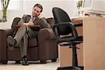 Businessman Using Cell Phone in Office