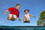 Man and Girl Bouncing on a Trampoline