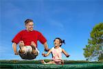 Man and Girl Bouncing on a Trampoline