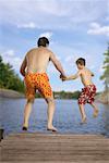 Father and Son Jumping into Lake